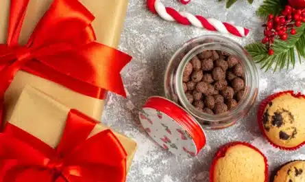 Vue rapprochée de délicieux petits cupcakes et du chocolat dans un pot en verre et des branches de sapin à côté