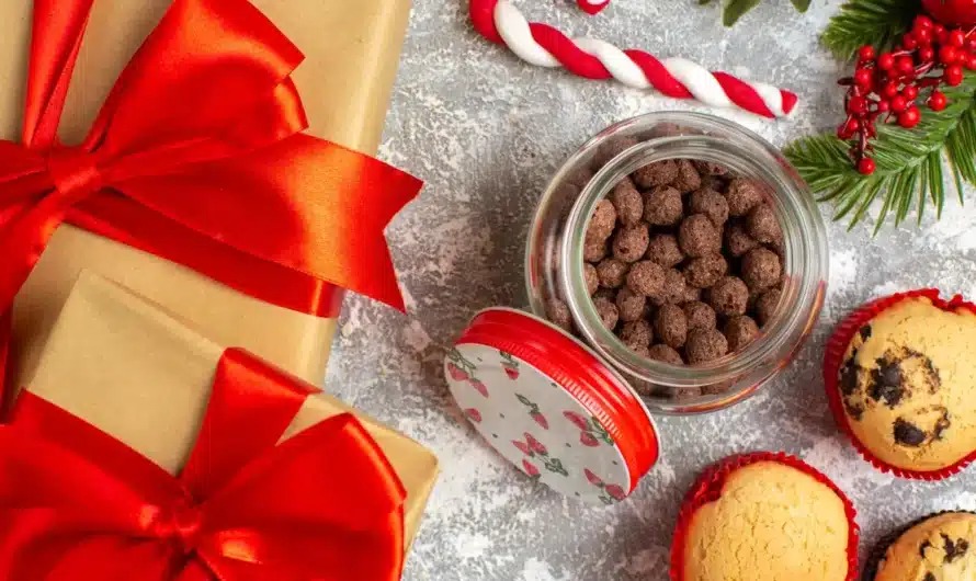 Vue rapprochée de délicieux petits cupcakes et du chocolat dans un pot en verre et des branches de sapin à côté